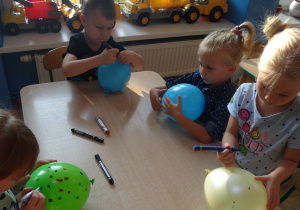 Dzieci rysują kropki na balonach